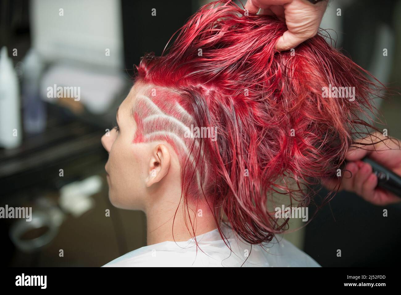 Coiffeur travaillant sur une coupe de cheveux rouge Photo Stock - Alamy