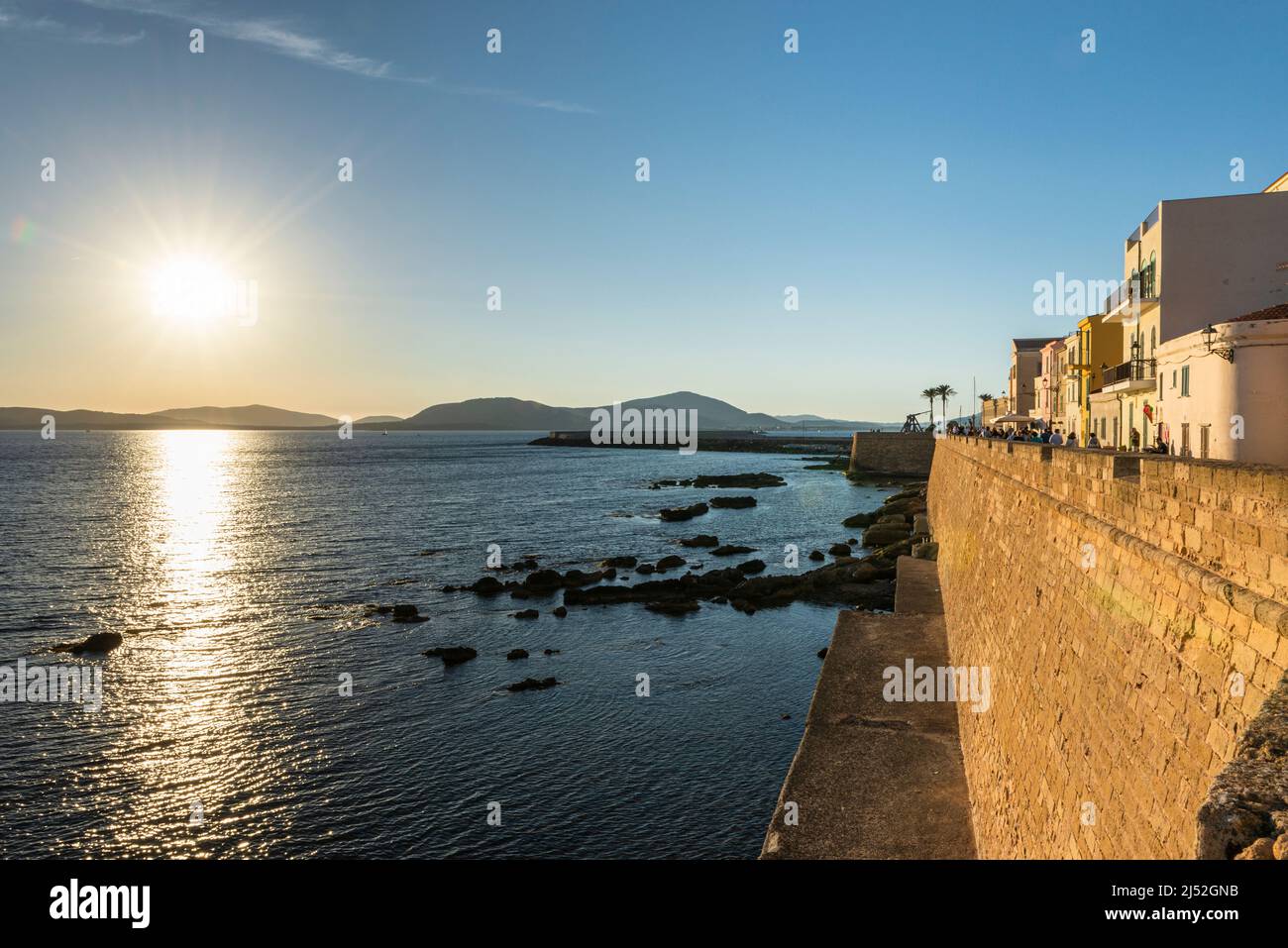 Belles villes de Sardaigne - coucher de soleil sur la baie, port, façades colorées et la promenade sur le mur de la forteresse à la vieille ville d'Alghero Banque D'Images