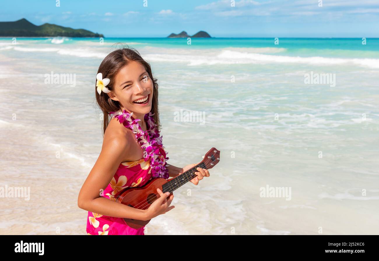 Hawaii luau ukulele hula dansant femme jouant de la guitare sur les  vacances à la plage avec collier de lei fleur et paero. Danseur asiatique  souriant lors d'un voyage à hawaï Photo