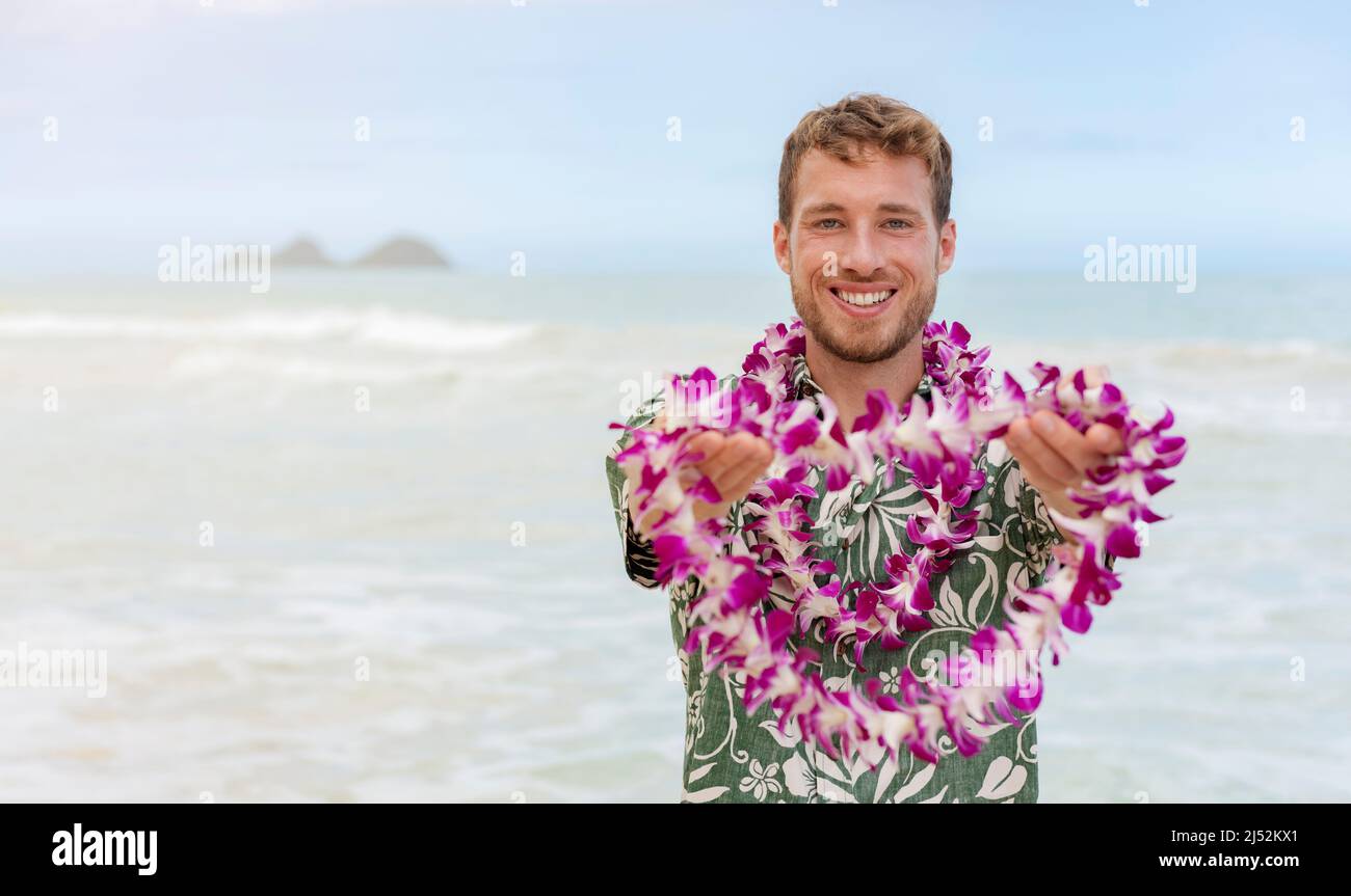 Hawaï accueille un homme caucasien dans une chemise hawaïenne accueillant le touriste donnant lei de fleurs fraîches comme geste d'esprit d'aloha sur la plage d'Hawaï pour la fête luau Banque D'Images