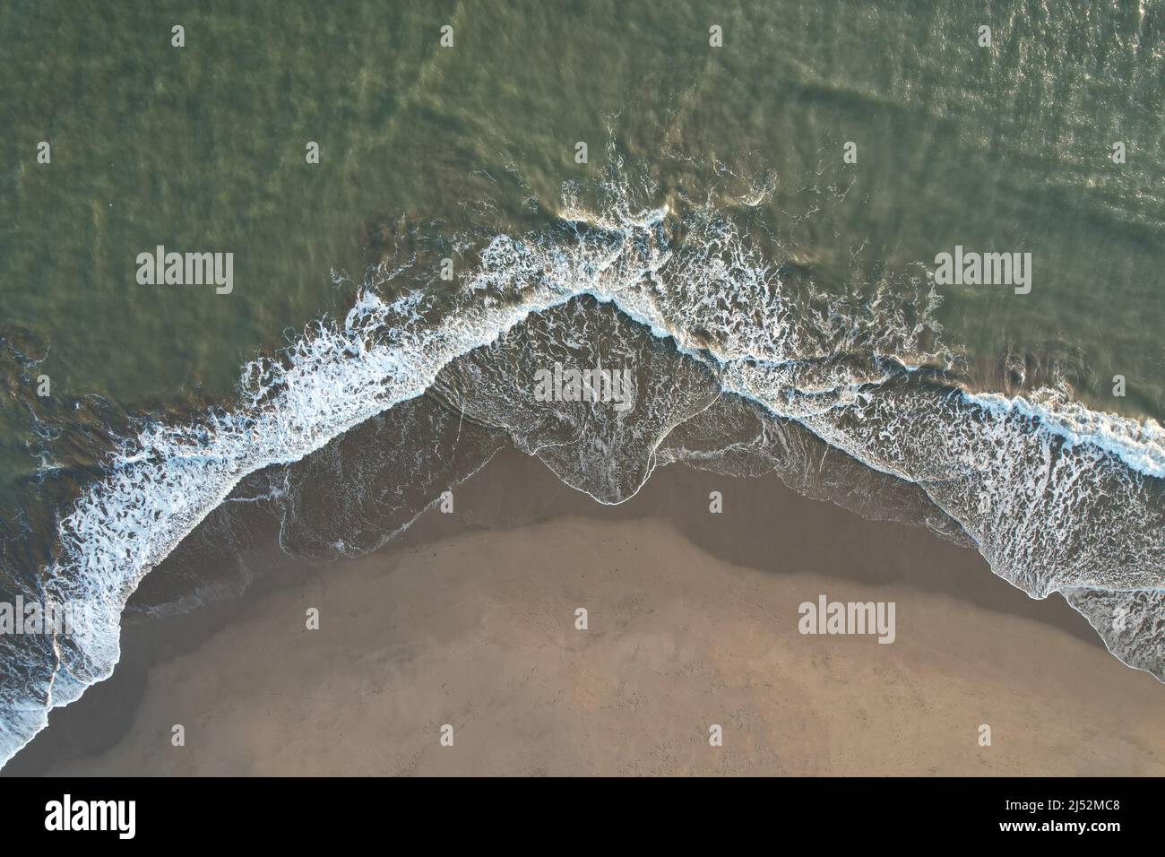 Sable humide avec petite vague de l'océan au-dessus de la vue de dessus de drone Banque D'Images