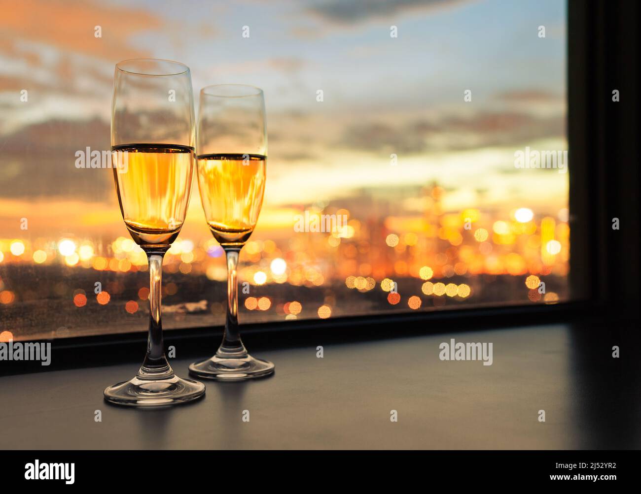 des verres de champagne et une belle vue romantique de nuit de la ville depuis la fenêtre. Banque D'Images