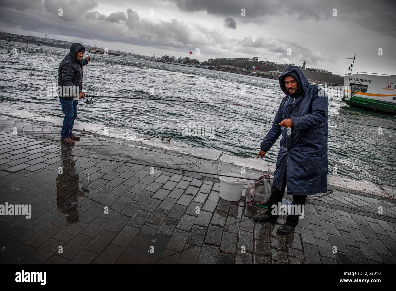 Les gens ont vu la pêche à la jetée de Karakoy avec une vue sur les lignes de ferry de la ville. Banque D'Images