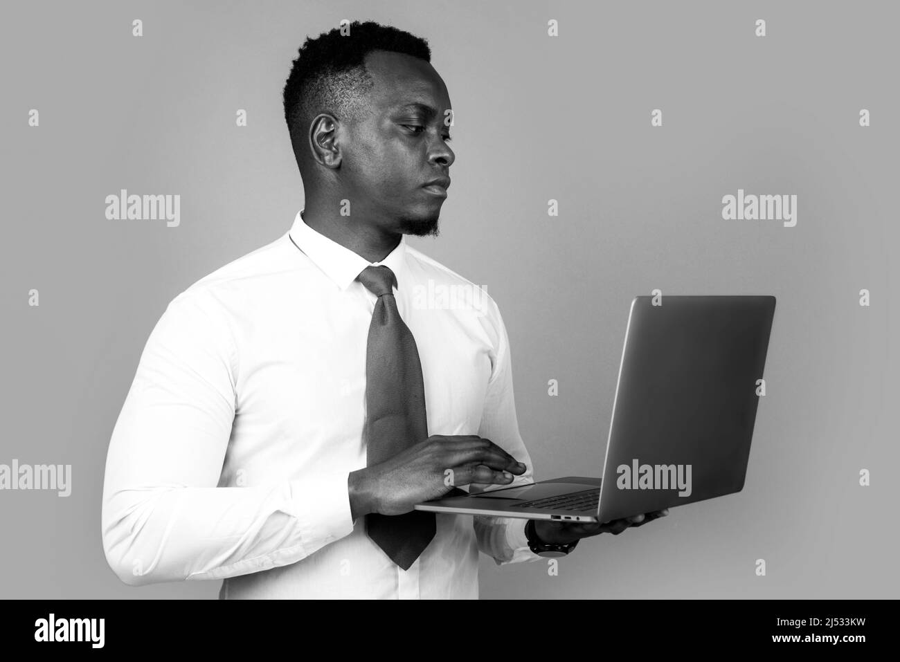 Jeune homme d'affaires utilisant un ordinateur portable et prenant des notes à la dentelle de travail dans le bureau moderne, espace libre Banque D'Images