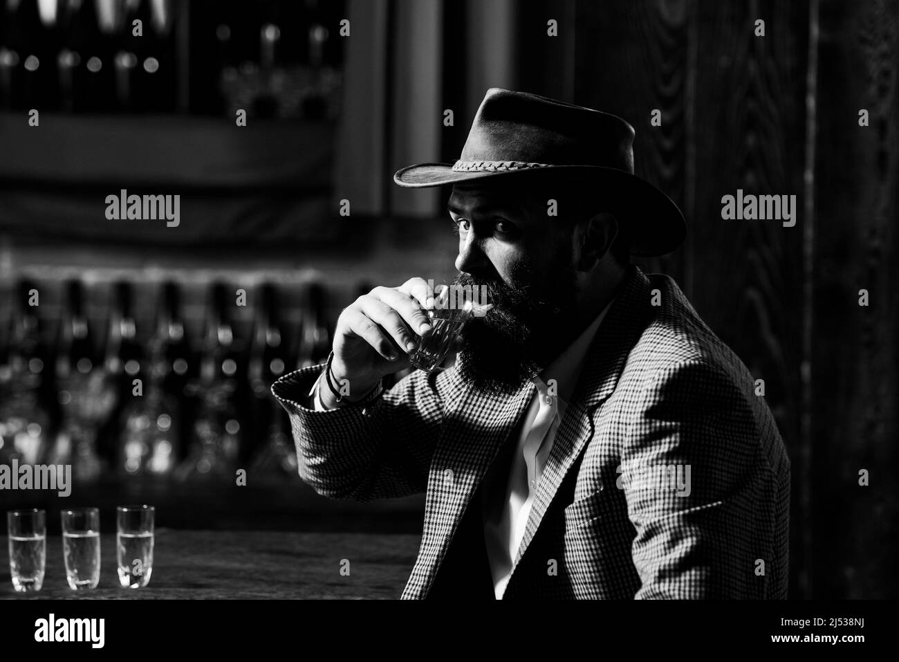 Dégustation et dégustation. Un homme avec une barbe tient un verre de brandy. Banque D'Images