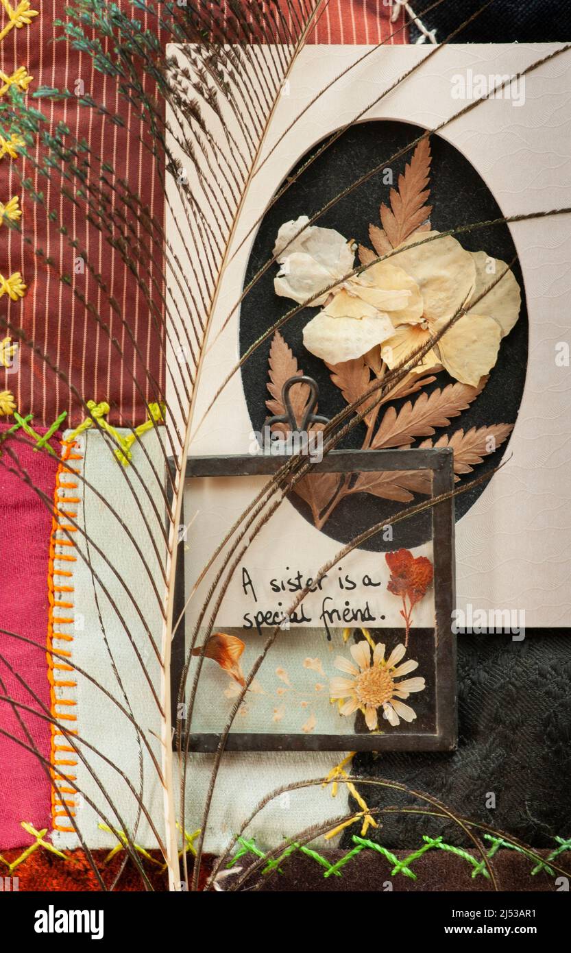Flat Lay soeur comme un ami avec la broche de coeur, les fleurs séchées, la courtepointe, et les plumes. À l'aide des arts et de l'artisanat, regardez dans la fenêtre pour le message ou le message d'accueil. Banque D'Images