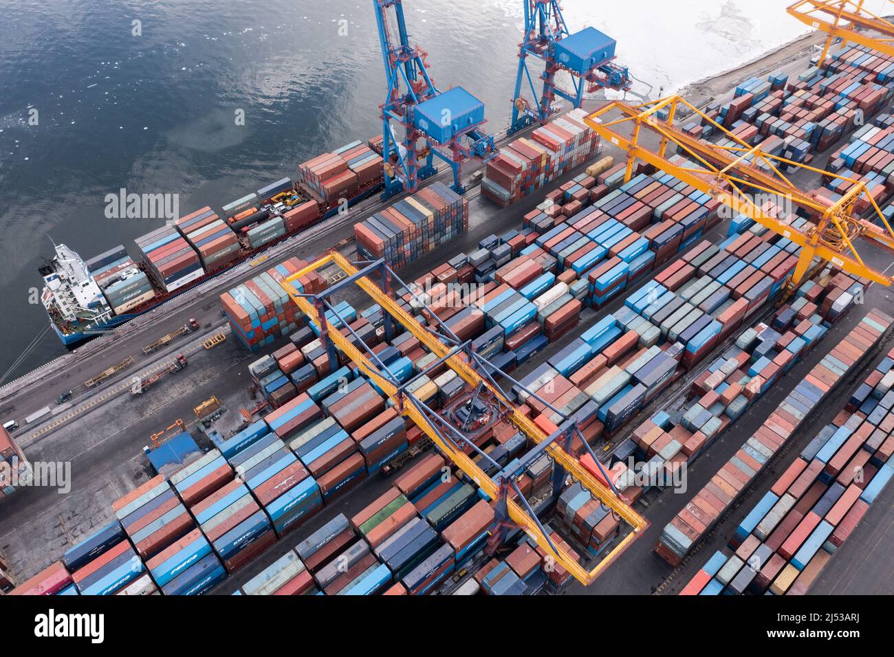 Vladivostok, Russie - 28 janvier 2022 : Vue de dessus du terminal des conteneurs du port maritime. En hiver, un bateau à conteneurs est en train de charger au quai. Banque D'Images