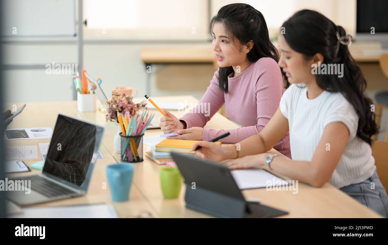 Les employées d'affaires concentrées écoutent son patron parler et la formation dans la réunion. Banque D'Images