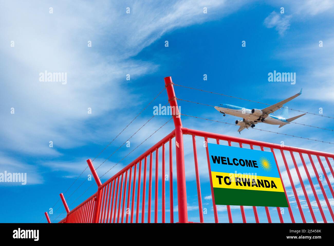 Avion volant au-dessus de la clôture de l'aéroport avec bienvenue au Rwanda sur le drapeau du Rwanda. UK offshore traitement de l'asile, la réinstallation, l'immigration... concept Banque D'Images