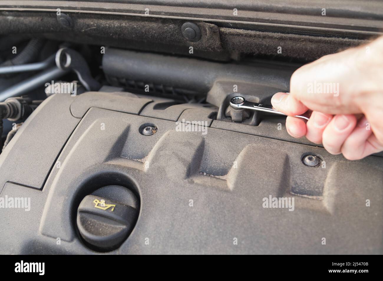 Mécanicien automobile utilisant une clé dans le service de réparation automobile. Réparation ou diagnostic du moteur Banque D'Images