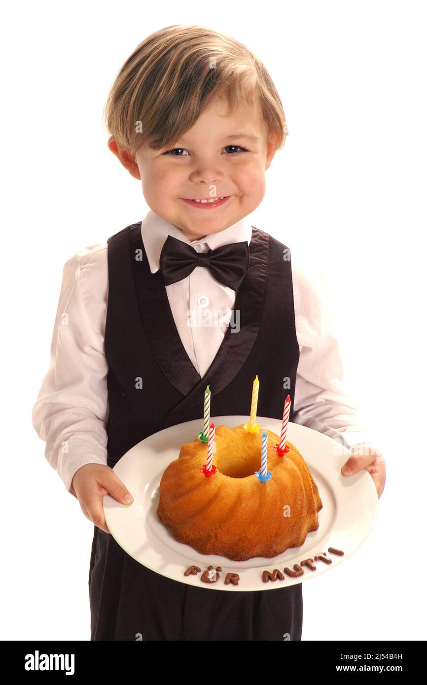 Petit garçon en costume avec un gâteau fait maison pour sa mère, 4 ans, Allemagne Banque D'Images