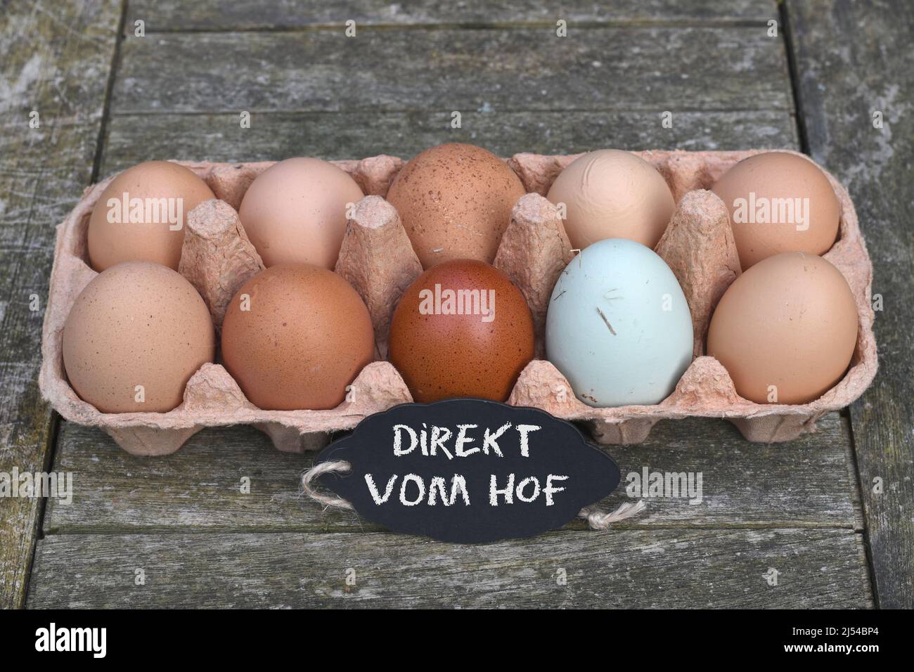 Tableau noir avec inscription « Direkt vom Hof » devant les œufs de poulet dans la boîte à œufs, Allemagne Banque D'Images