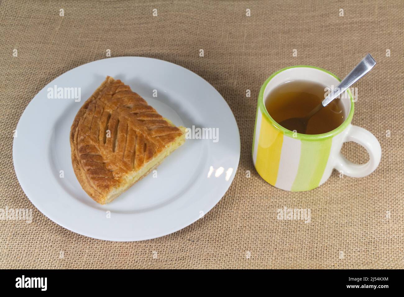 Une tasse de thé et un morceau de gâteau français sur une assiette Banque D'Images