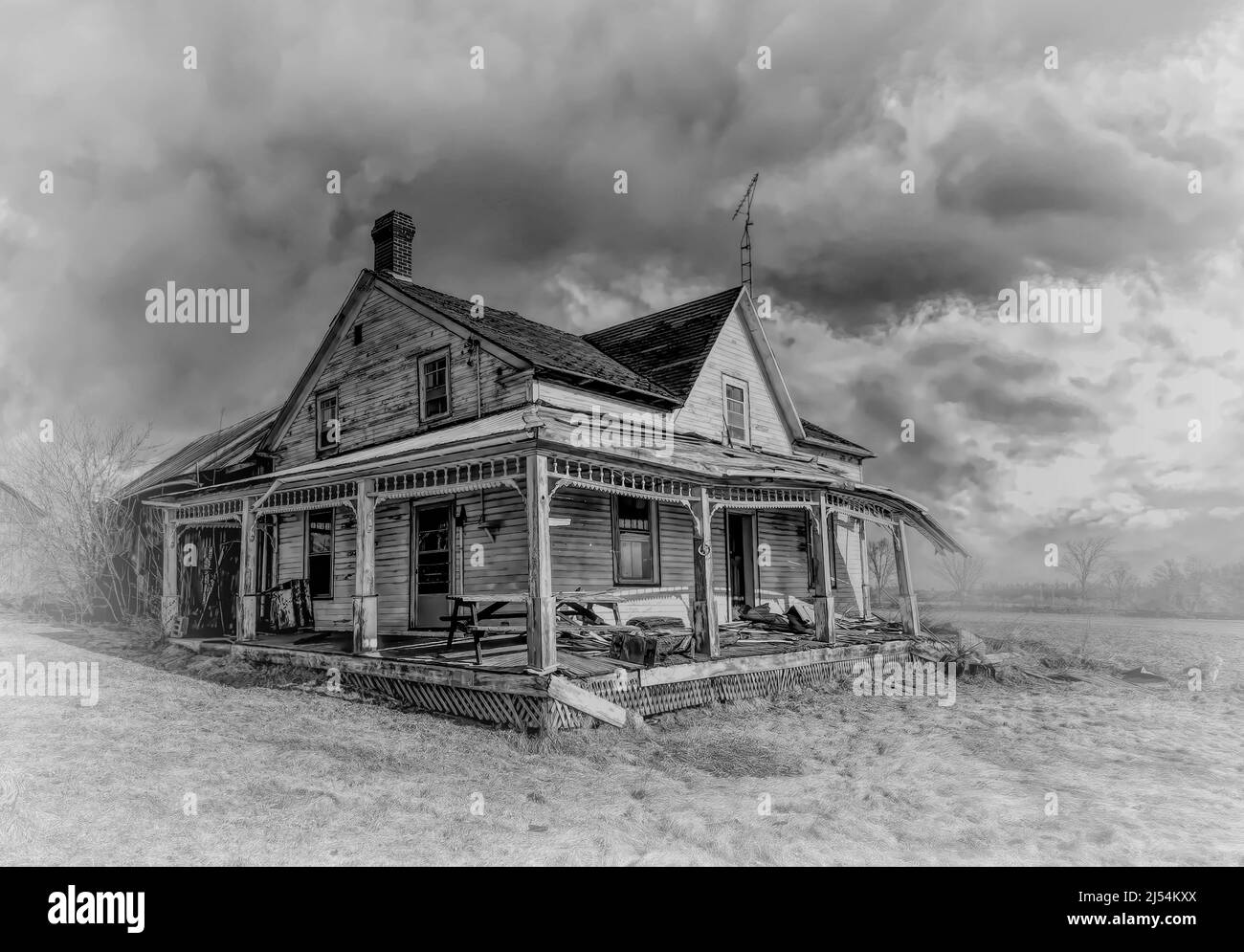 Une ancienne ferme noire et blanche abandonnée à l'aspect sinistre en hiver sur une cour de ferme dans les régions rurales du Canada Banque D'Images