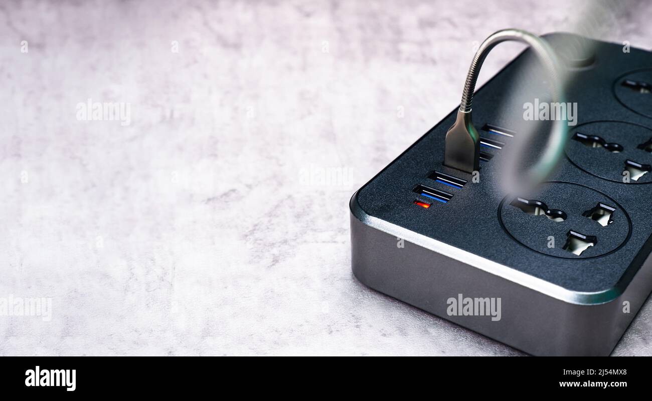 Adaptateur avec port USB et prise multiple pour le chargement de téléphone portable ou d'appareil électrique domestique sur le sol en ciment Banque D'Images