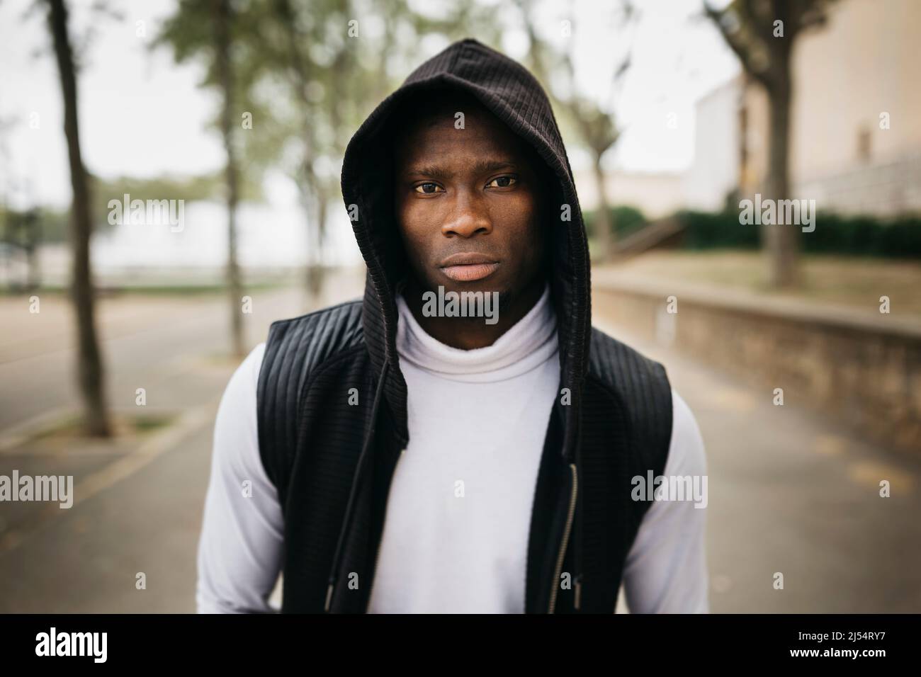 Portrait d'un jeune homme noir à capuchon dans la rue Banque D'Images
