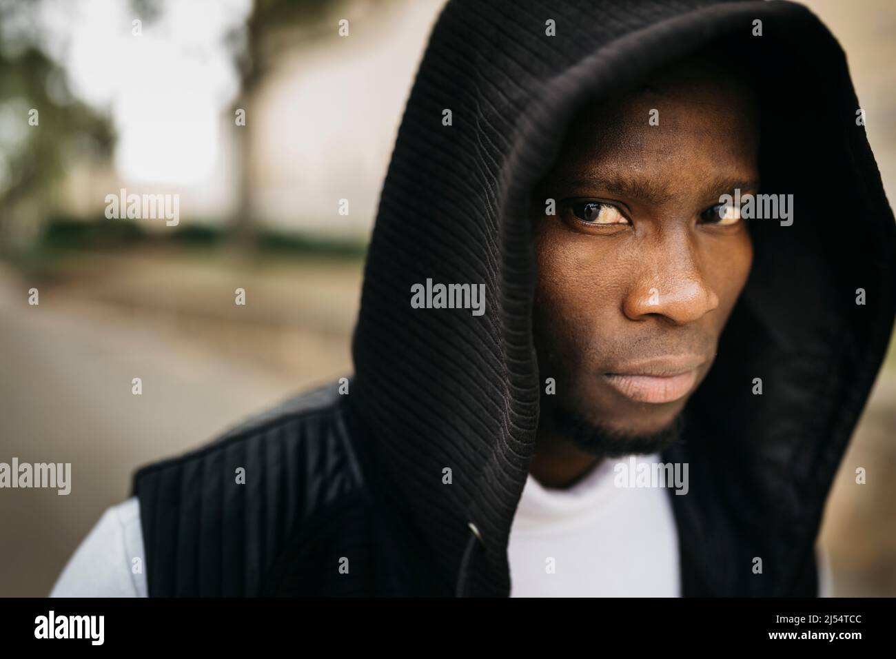 Portrait d'un jeune homme noir à capuchon dans la rue Banque D'Images