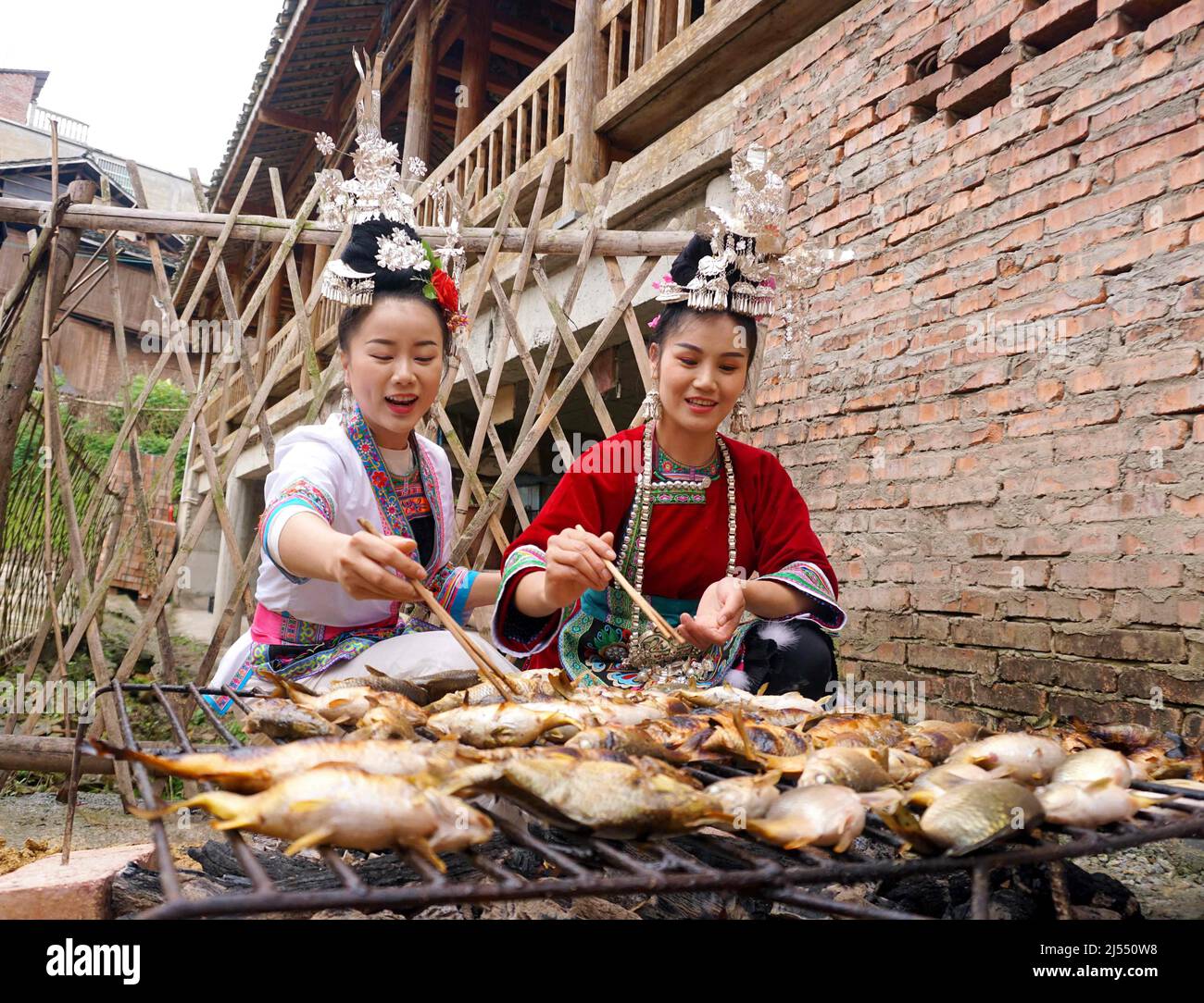 CONGJIANG, CHINE - le 20 AVRIL 2022 - une ancre fabrique des poissons grillés lors d'un événement dans le comté de Congjiang, dans la province de Guizhou, dans le sud-ouest de la Chine, le 20 avril 2022. Banque D'Images