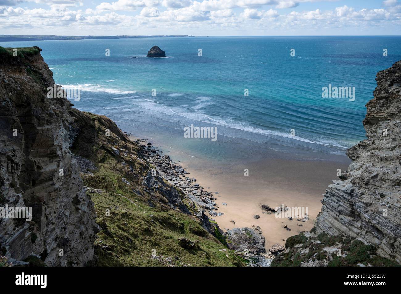 Le sable doré de la plage de Trebarwith Strand, North Cornwall, Royaume-Uni avec l'île de Gull Rock, les falaises et la mer turquoise. Banque D'Images