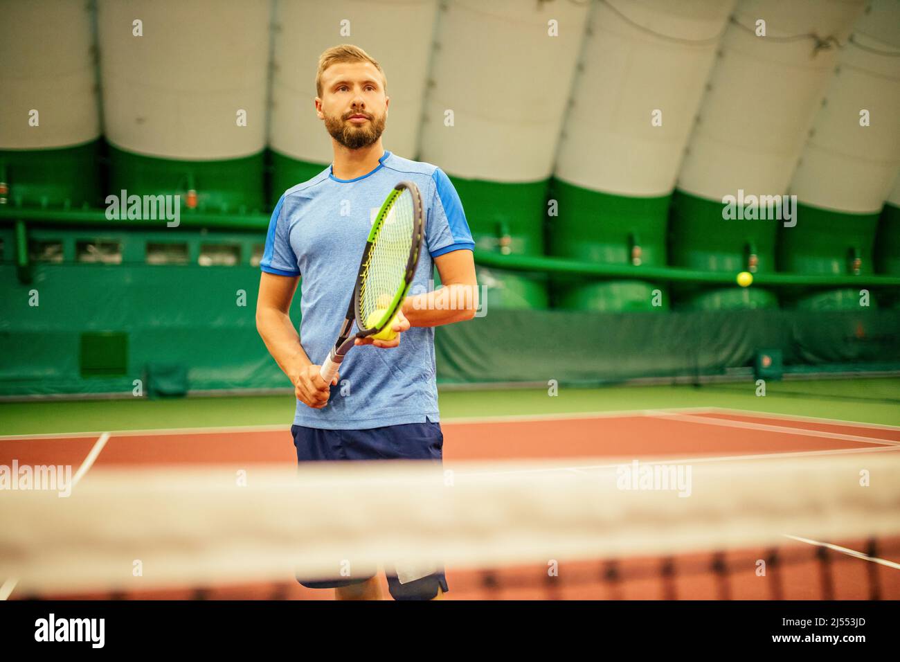 Instructeur ou entraîneur enseignant comment jouer au tennis sur un court à l'intérieur Banque D'Images