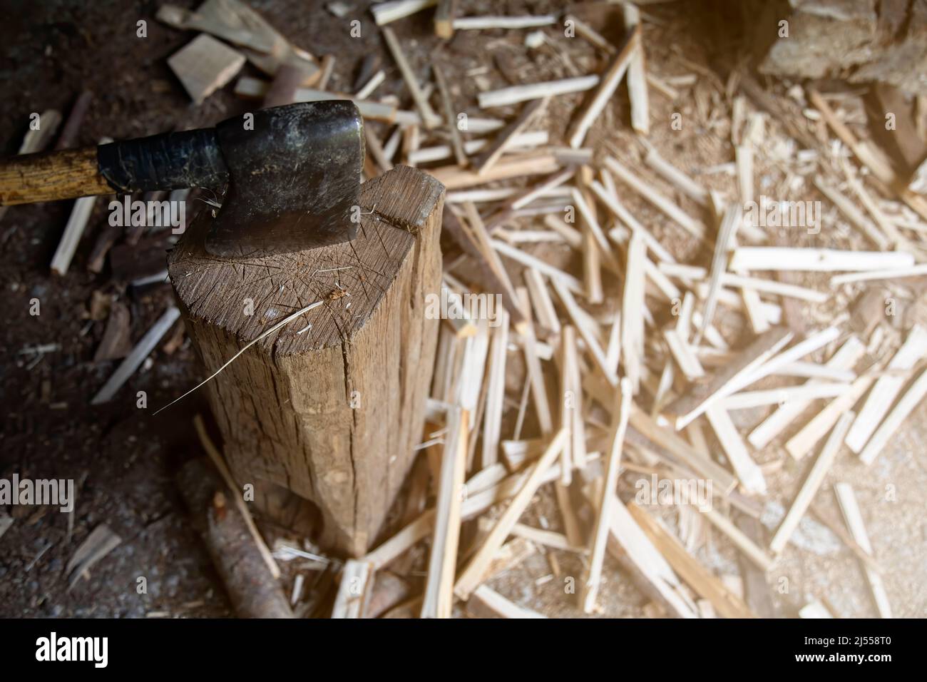 photographie d'une hache clouée à un fond et couper le bois sur le sol à placer dans la salle de stockage. vie rurale. espace de copie. arrière-plan Banque D'Images
