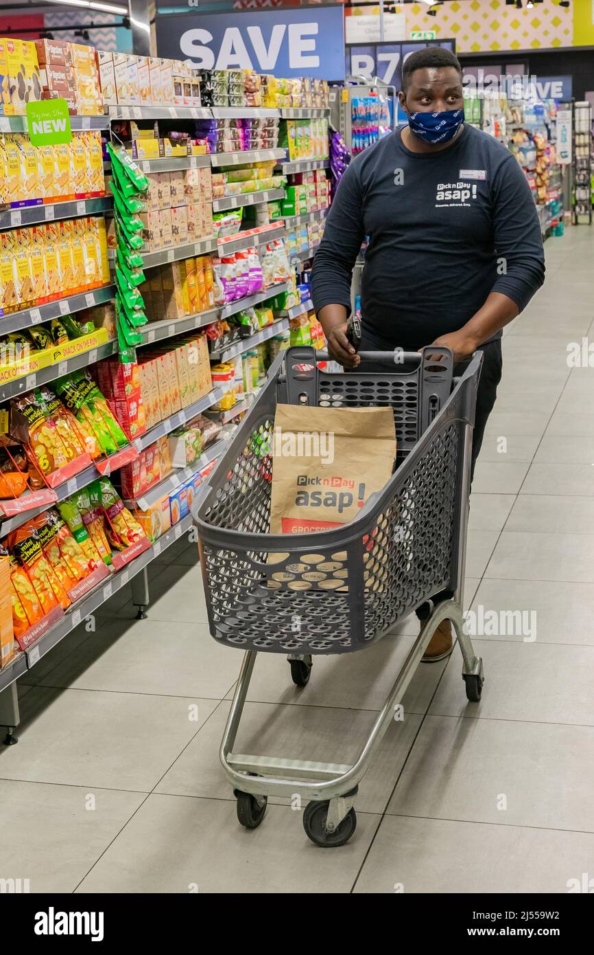 Cape Town, Afrique du Sud - 9 septembre 2021 : un membre du personnel cueille des produits à partir de l'étagère pour un service de livraison express à domicile Banque D'Images