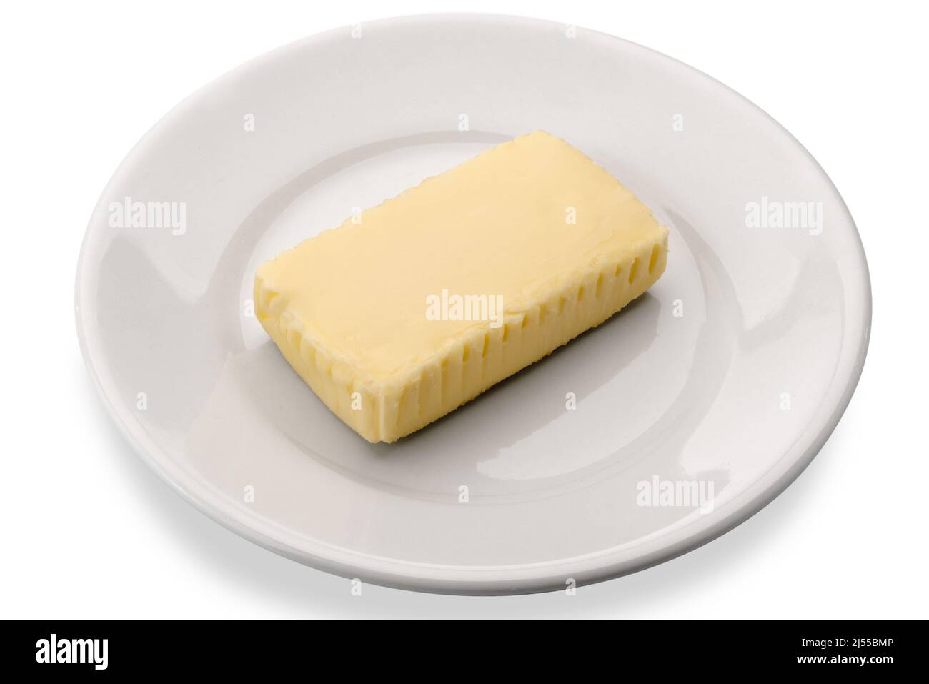 Morceau de beurre centrifugé dans un plat blanc isolé sur blanc Banque D'Images
