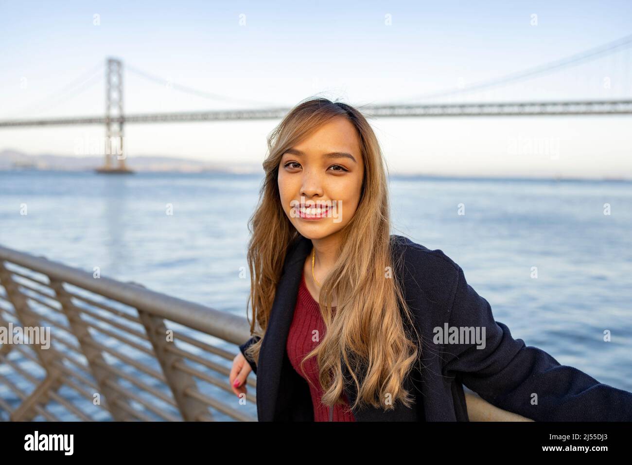 Jeune femme asiatique avec Oakland Bay Bridge et la baie de San Francisco en arrière-plan Banque D'Images