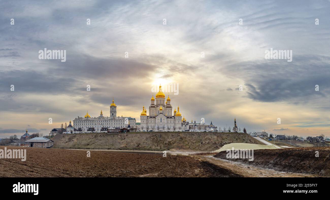 Vue magique de la Sainte Dormition Pochayiv Lavra en Ukraine. Vue panoramique. Lumière du soleil sur le monastère. Les nuages noirs s'accumulent. Banque D'Images