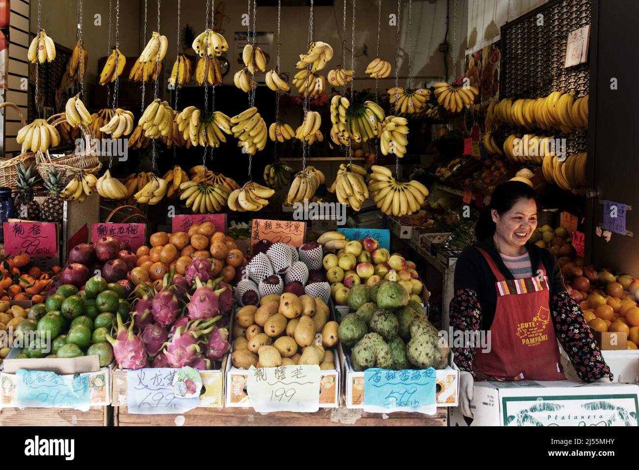 Femme vendant des produits frais sur les marchés de produits du quartier chinois de San Francisco avec une large sélection de fruits communs et exotiques Banque D'Images