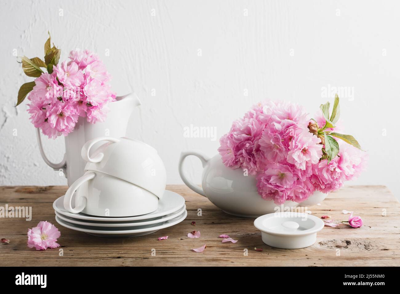 Tasses blanches, théière et cerisiers en fleurs japonais. La durée de vie du printemps. Banque D'Images