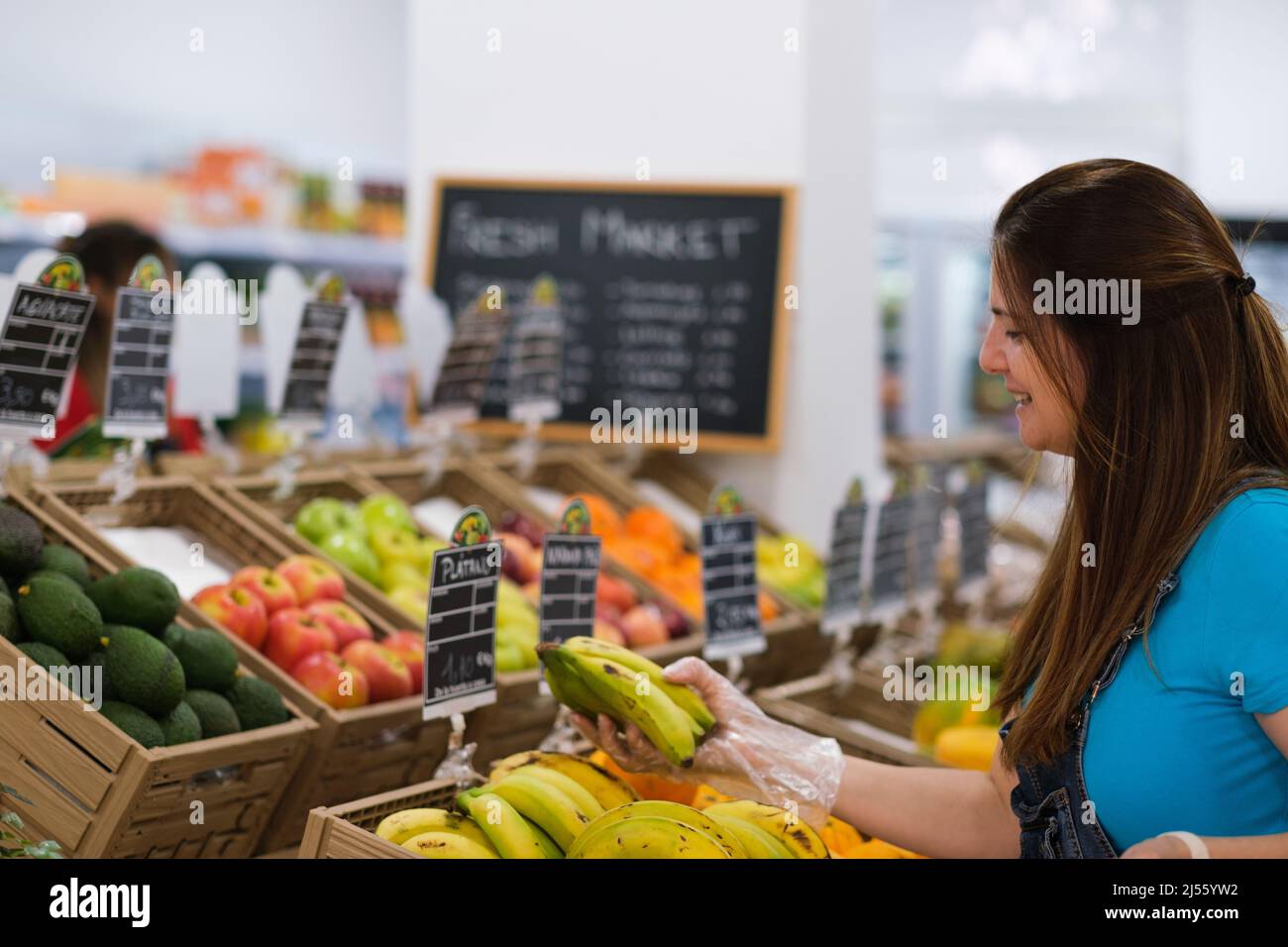 Femme âgée qui choisit des fruits sur le marché Banque D'Images