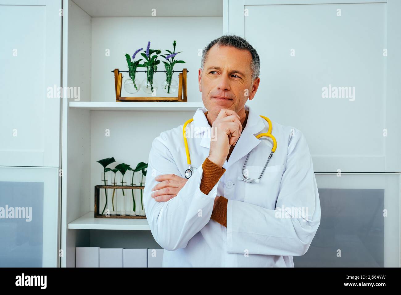 portrait en gros plan de médecin pensif masculin médecin en blouse de laboratoire avec stéthoscope regardant loin de l'espace de copie Banque D'Images