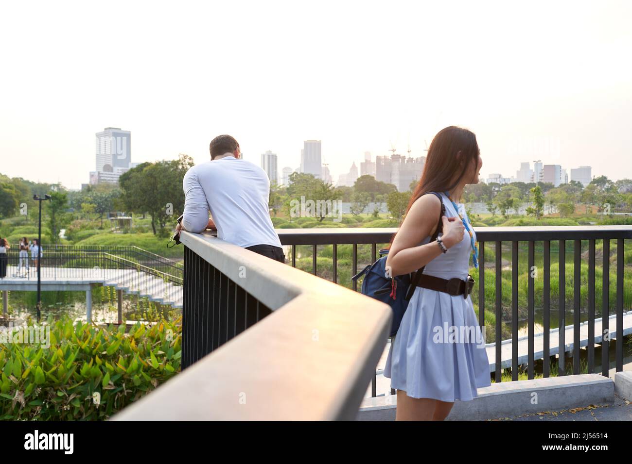 couple regardant le paysage urbain avec des gratte-ciels depuis un parc au coucher du soleil Banque D'Images