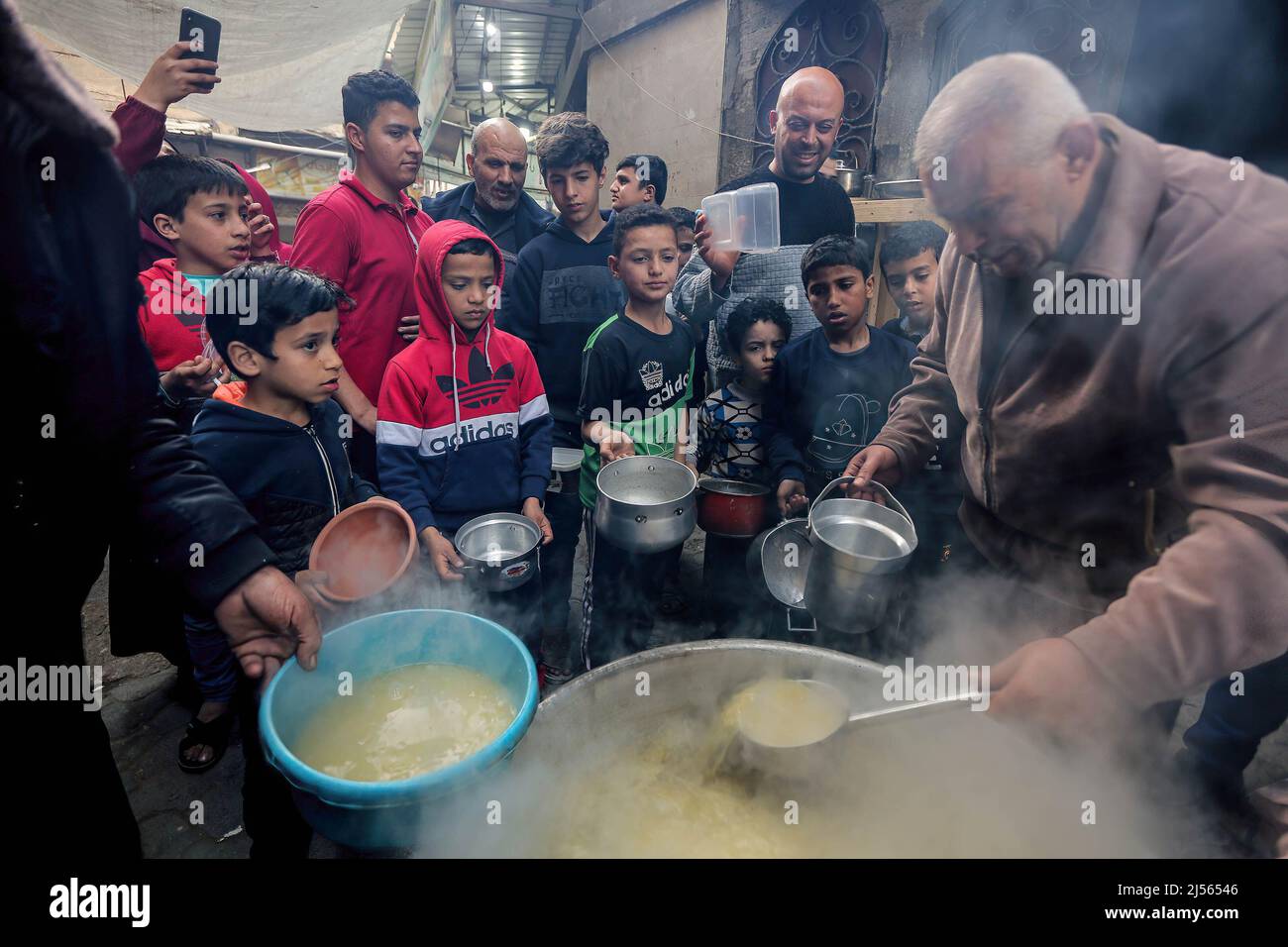 Les Palestiniens reçoivent de la soupe gratuite pendant le ramadan dans le quartier de Shejaiya, dans la ville de Gaza. Les musulmans du monde entier célèbrent le Saint mois du Ramadan en priant pendant la nuit et en s'abstenant de manger et de boire entre le lever et le coucher du soleil. Ramadan est le neuvième mois du calendrier islamique et on croit que le premier verset du Coran a été révélé au cours de ses dix dernières nuits. Banque D'Images