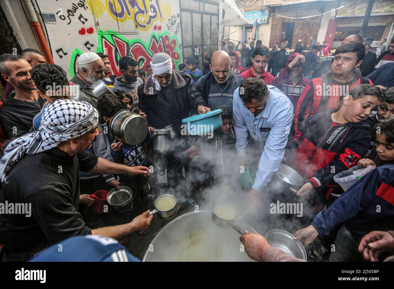 Gaza, Palestine. 20th avril 2022. Les Palestiniens reçoivent de la soupe gratuite pendant le ramadan dans le quartier de Shejaiya, dans la ville de Gaza. Les musulmans du monde entier célèbrent le Saint mois du Ramadan en priant pendant la nuit et en s'abstenant de manger et de boire entre le lever et le coucher du soleil. Ramadan est le neuvième mois du calendrier islamique et on croit que le premier verset du Coran a été révélé au cours de ses dix dernières nuits. (Photo de Yousef Masoud/SOPA Images/Sipa USA) crédit: SIPA USA/Alay Live News Banque D'Images