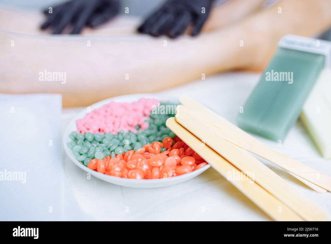 Sugaring: Femme au salon de cosmétiques cirant les jambes Banque D'Images