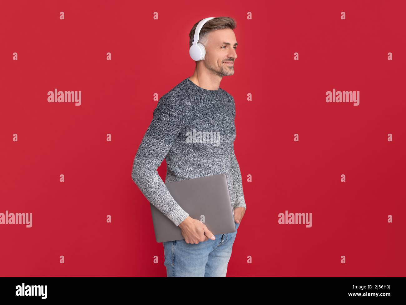 E-éducation même de loin. Un homme heureux dans un casque tient un ordinateur portable. E-éducation et e-école Banque D'Images