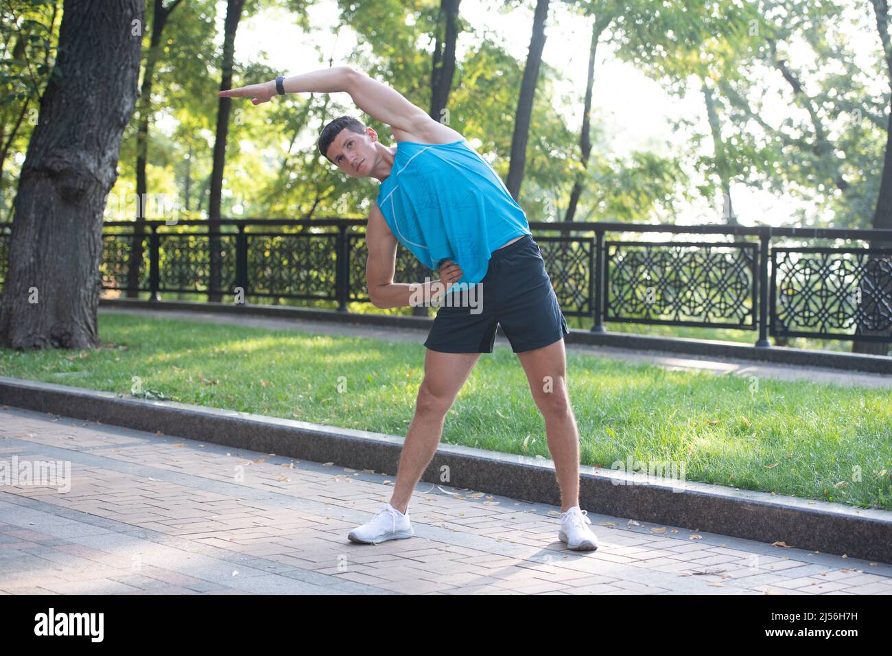 homme actif dans des vêtements de sport faisant de l'exercice d'échauffement Banque D'Images