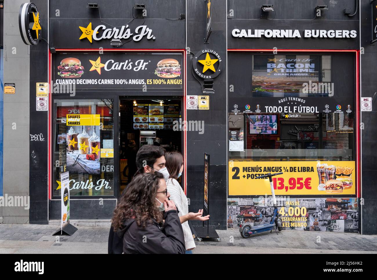 Des piétons marchent devant la chaîne de restauration rapide américaine Carl's Jr (Carls Jr) en Espagne. Banque D'Images