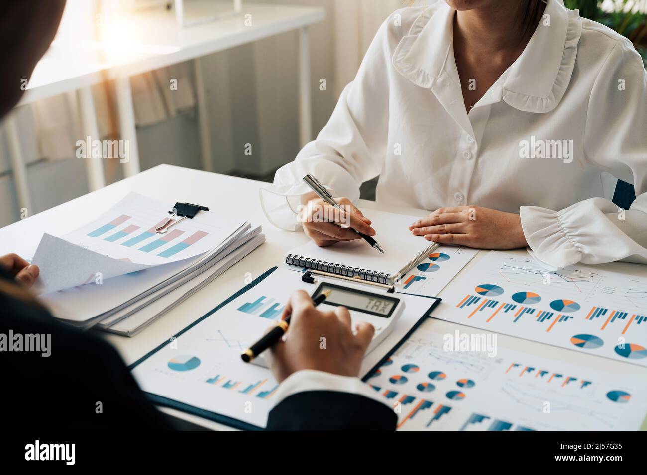 Conseiller financier travaillant avec le client, en calculant et en analysant les données paperboard pour l'équipe de réunion dans la salle de bureau. Concept finance et comptabilité Banque D'Images