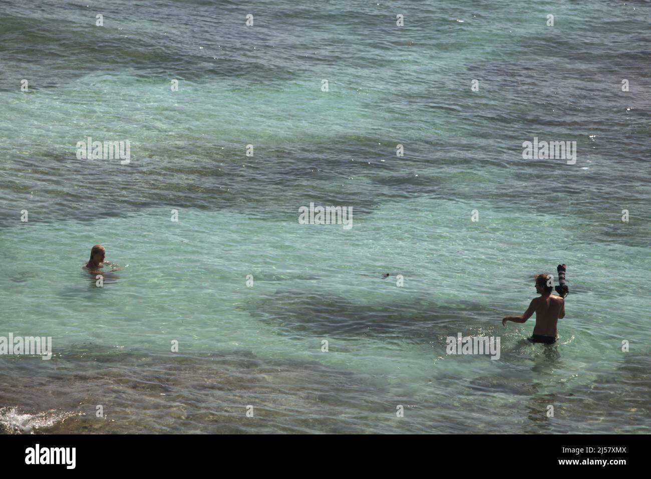 Un photographe est sur le point de prendre la photo d'une femme sur la plage de Padang-padang à Labuan Sait, au sud de Kuta, à Bali, en Indonésie. Banque D'Images