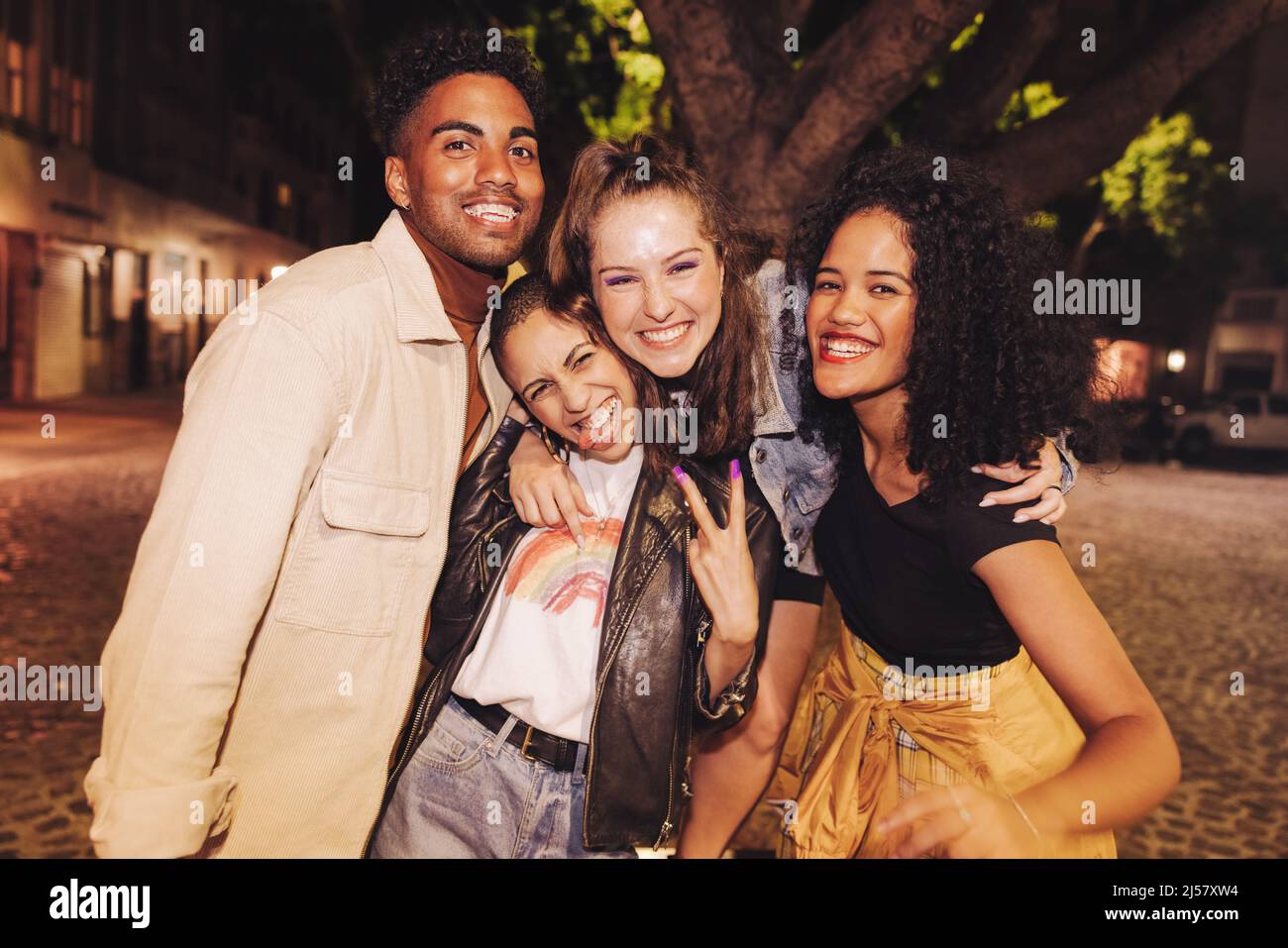 Groupe d'amis multiculturels souriant à l'appareil photo avec joie. De jeunes amis heureux qui se sont bien réunis à l'extérieur. Vibrant y Banque D'Images