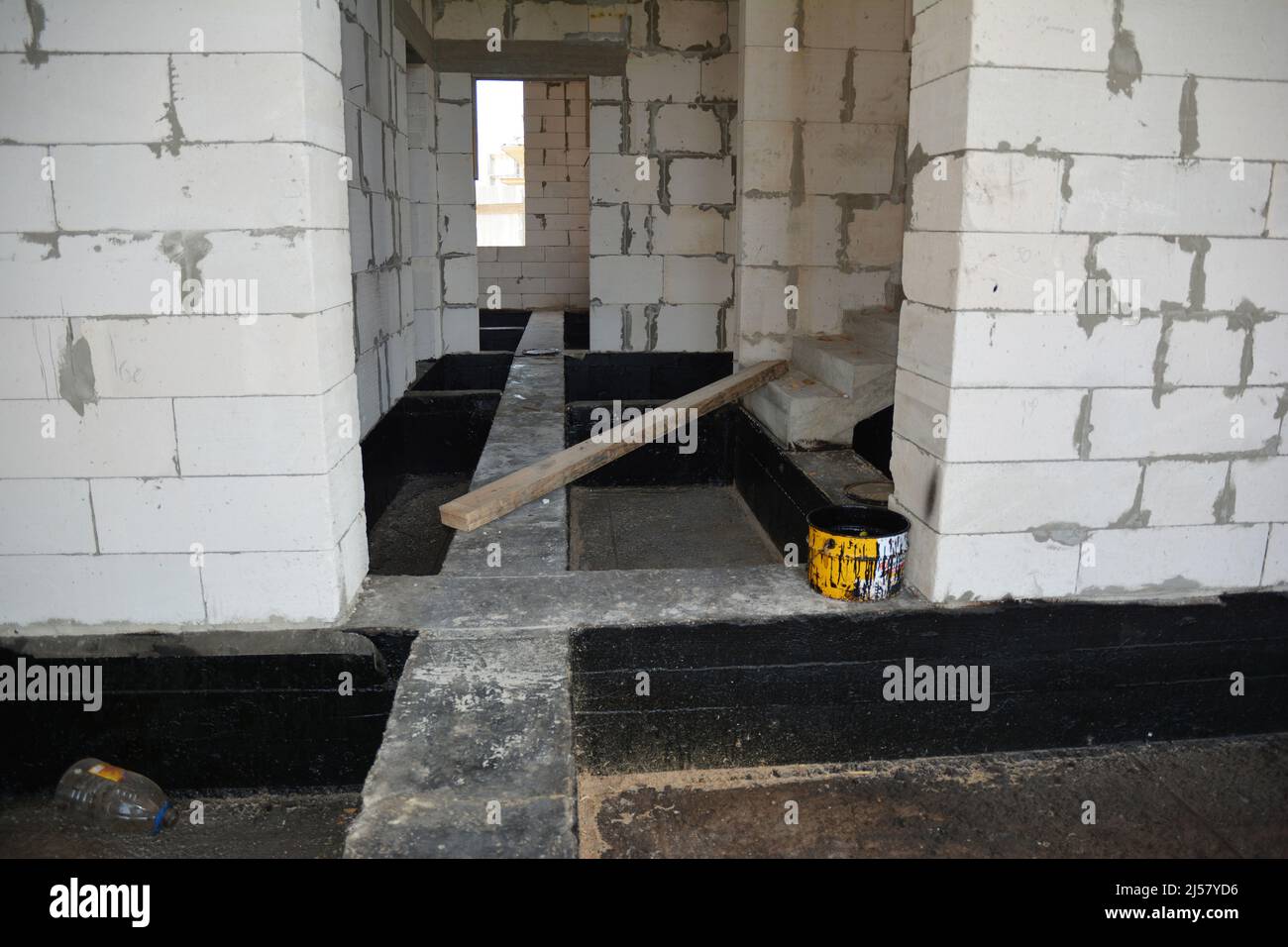 Bitume Fondation imperméabilisation. Bâtiment maison construction avec spray imperméabilisant-sur goudron. Techniques de construction de base d'imperméabilisation de pulvérisation Banque D'Images