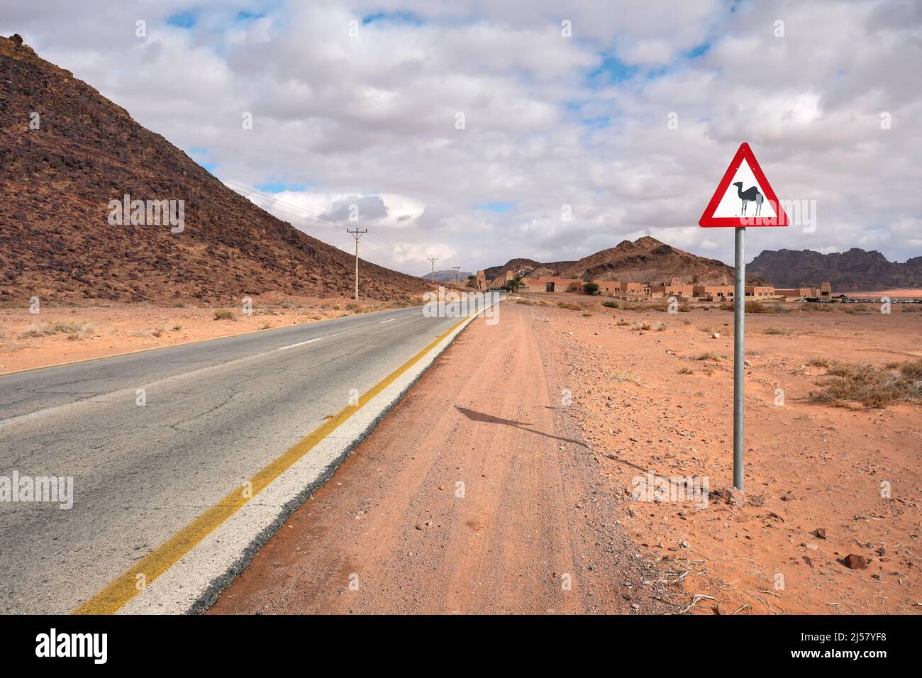 Route désertique vide à Wadi Rum, triangle rouge avertissement Camels près. Banque D'Images