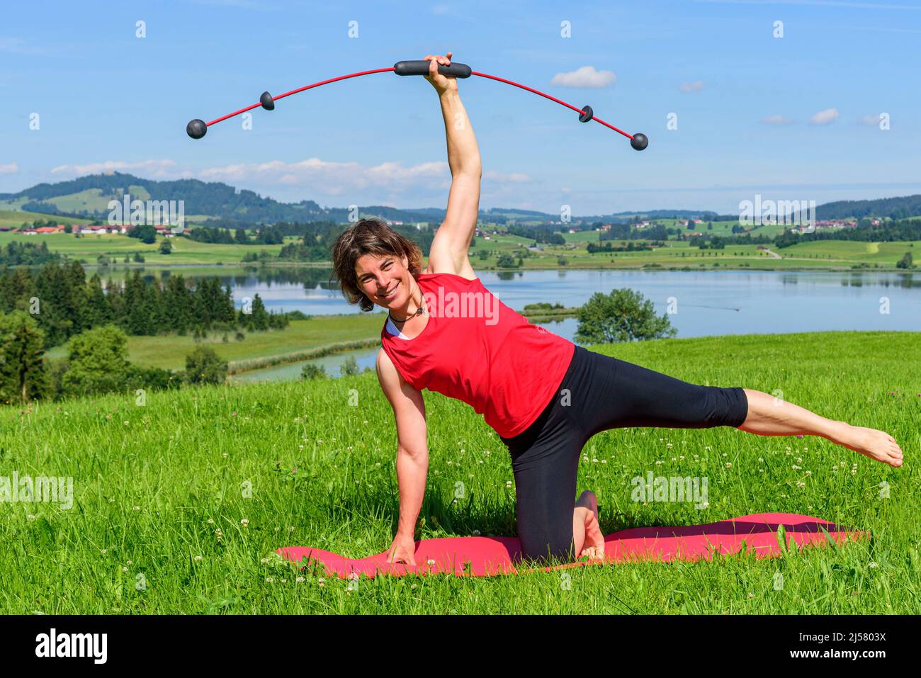 Femme faisant des exercices pilates avec barre vibrante Banque D'Images
