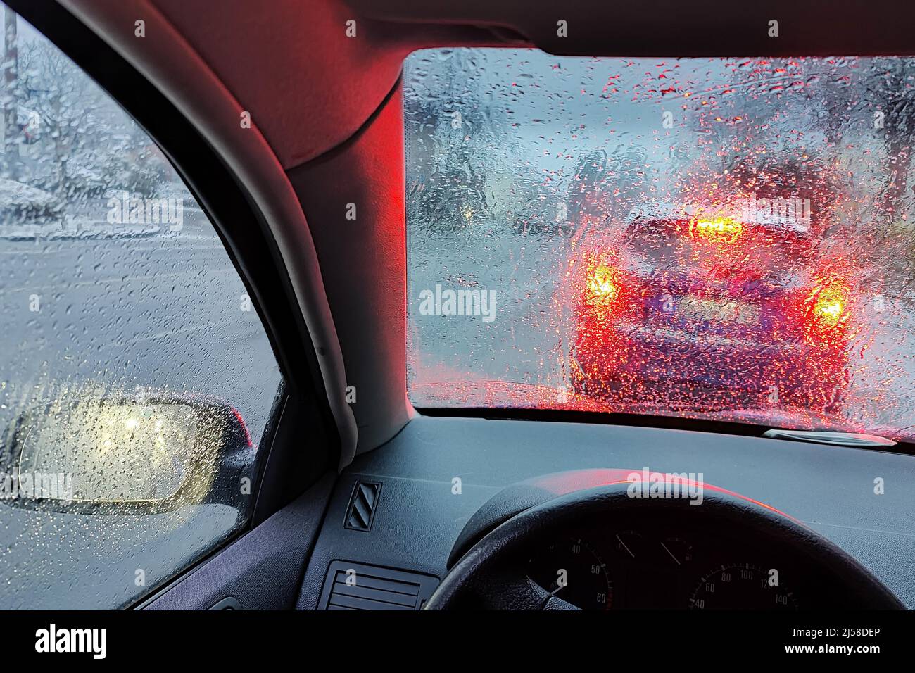 Blick aus dem Auto durch eine regengasse Scheibe mit unklarer Sicht auf den Verkehr am Abend, Witten, Ruhrgebiet, Deutschland Banque D'Images