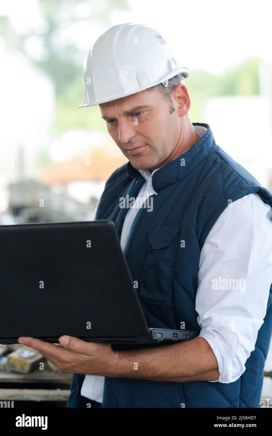 homme dans un casque travaillant à l'extérieur de l'ordinateur portable Banque D'Images