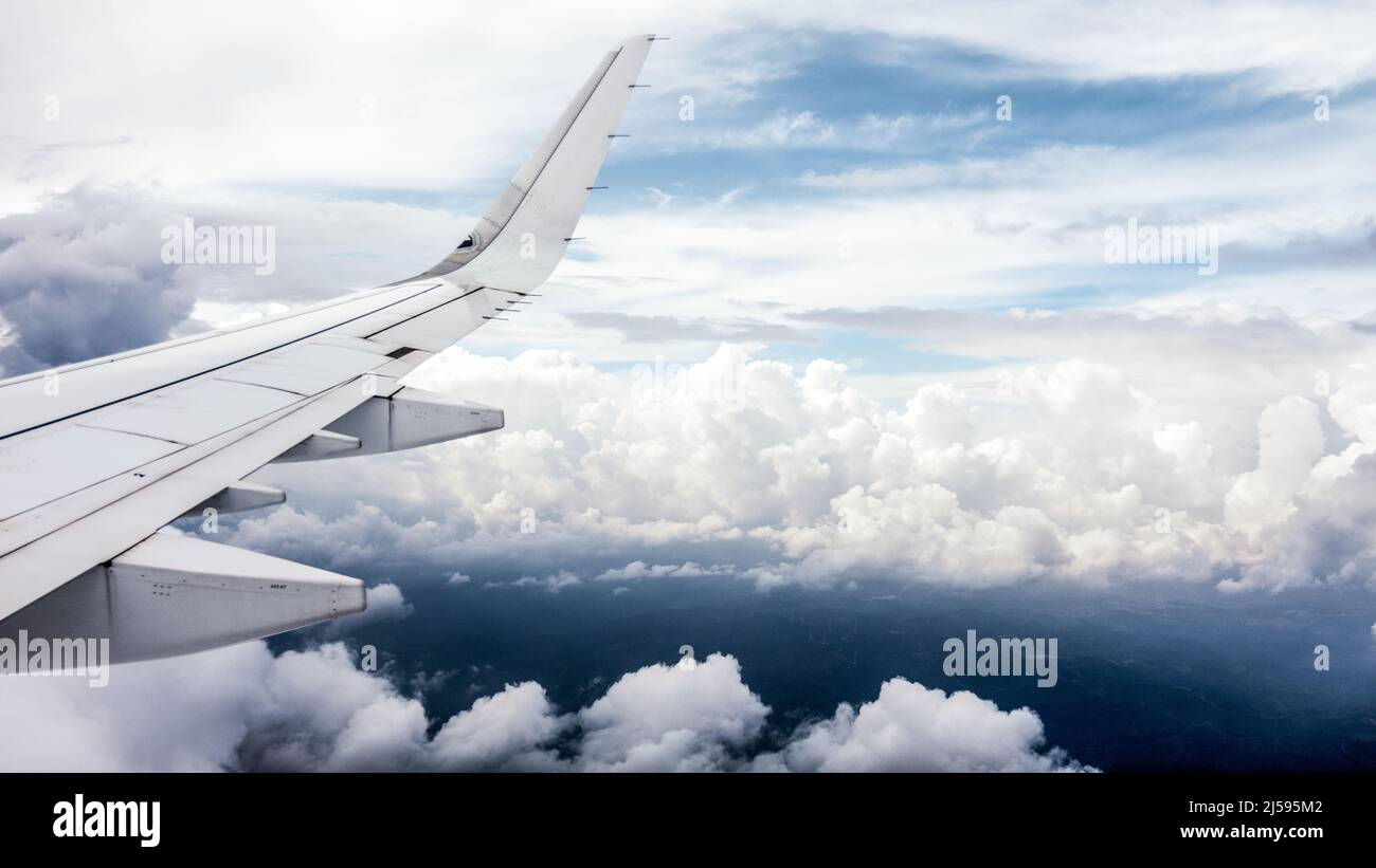 Vue latérale hors de l'avion passager Airbus A321neo. Des nuages rêvants derrière l'aile droite de l'avion. Banque D'Images