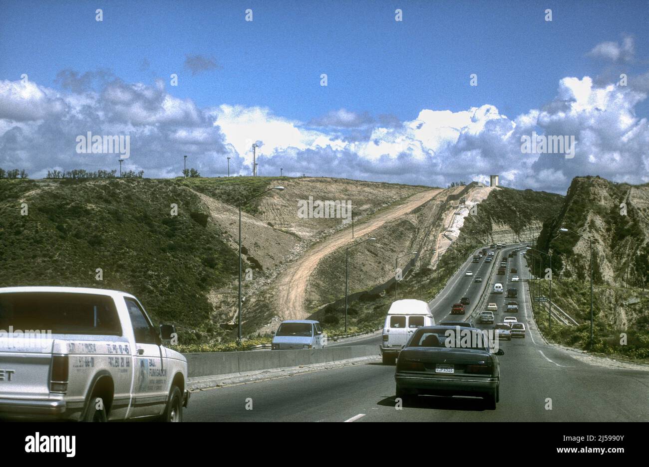Une route à deux voies près de Tijuana, parallèle à la frontière mexicaine avec les Etats-Unis. USA à gauche et le Mexique à droite. Banque D'Images